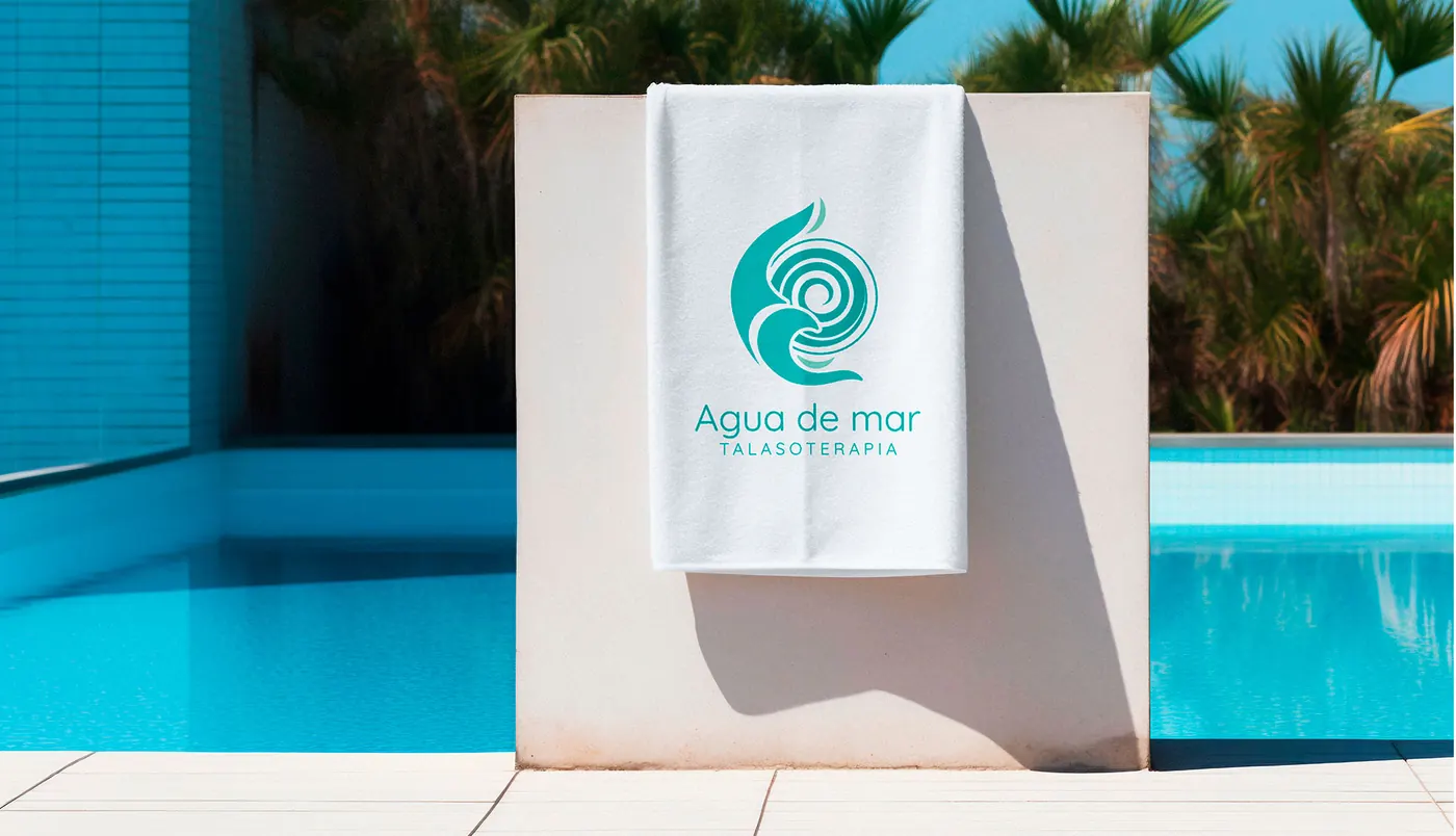 Toalla con el logo de Agua de Mar junto a una piscina